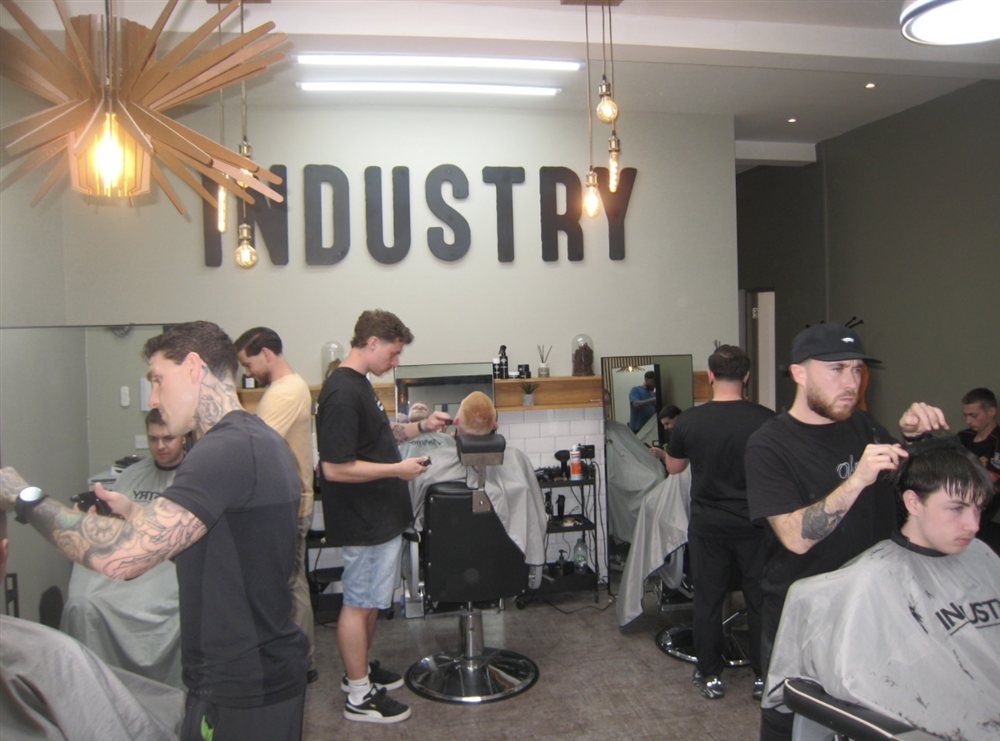The team cutting hair under the Industry sign on a busy day